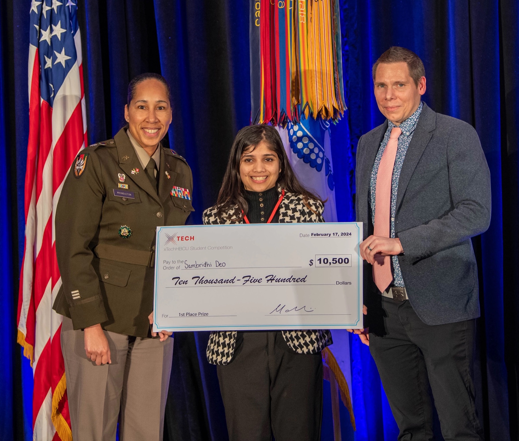 Sam holding the first-place xTech award with Army officials